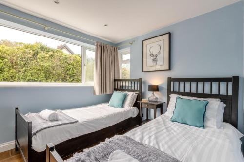 two beds in a room with a window at 4 Bed in Braunton oc-56111 in Croyde
