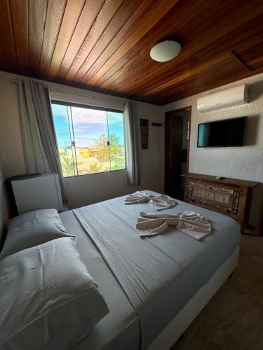 a bedroom with a bed with towels on it at Pousada Casa do Telhado Verde in Cabo Frio