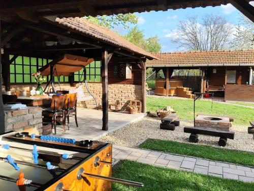 a pavilion with a table and a grill and a picnic table at Bóbita Apartmanház in Szilvásvárad