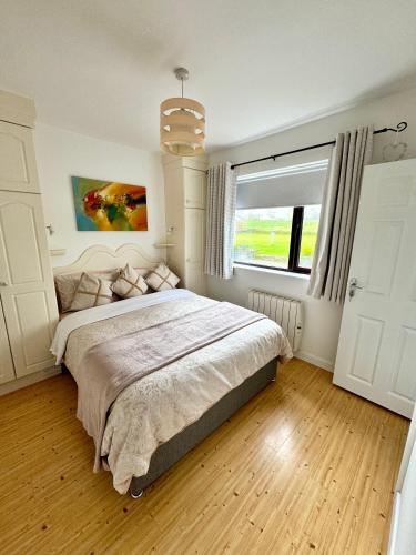 a bedroom with a large bed and a window at Inisfail in Killarney
