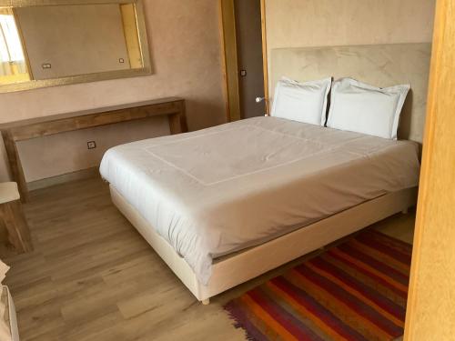 a bedroom with a large white bed with a mirror at DOMAINE VILLa in Tameslouht
