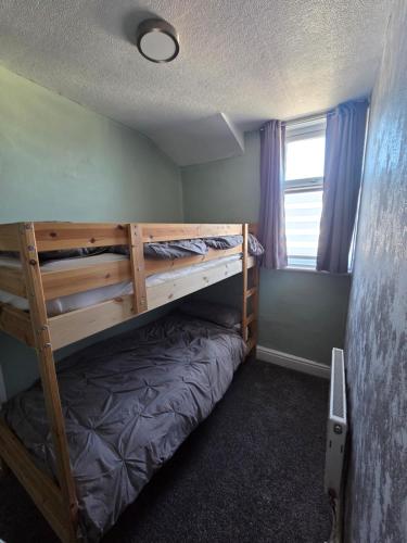 a bedroom with two bunk beds and a window at Martell's Hotel in Blackpool