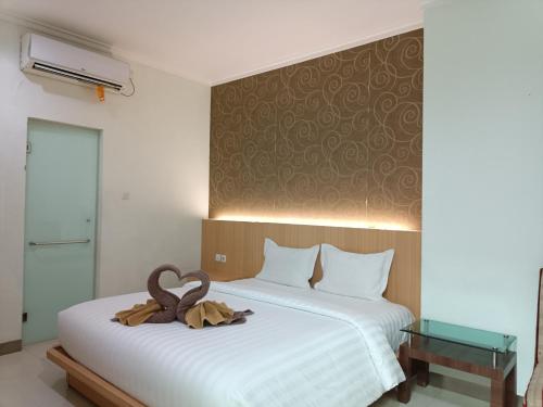 a bedroom with a bed with two swans on it at The Cabin Hotel Wirobrajan in Yogyakarta