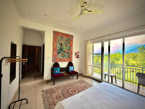 a bedroom with a bed and a balcony at Social Monkey Hostel Bir in Bīr