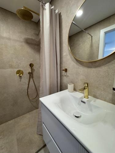 a bathroom with a white sink and a mirror at Baltic Avenue in Klaipėda