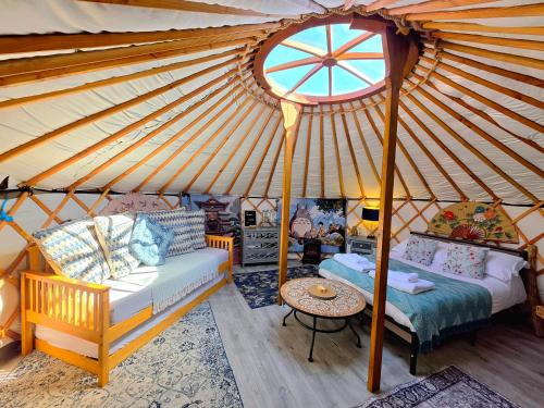 a room with a yurt with a bed and a table at Rainbow's End Yurts in Dornoch