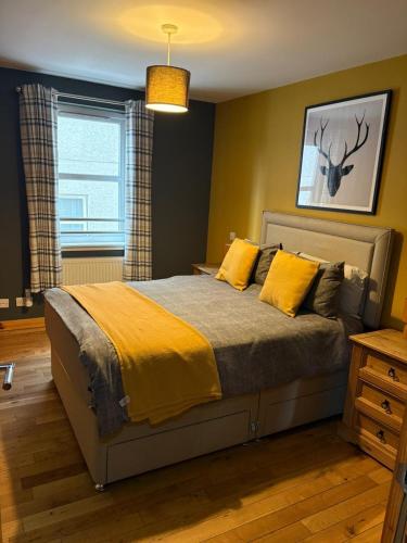 a bedroom with a bed with yellow sheets and a window at Metro 8 Inverness City Centre in Inverness
