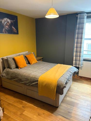 a bedroom with a bed with orange pillows on it at Metro 8 Inverness City Centre in Inverness