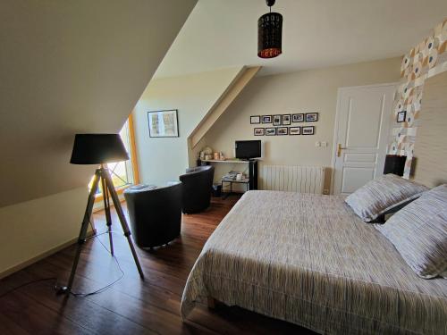 a bedroom with a bed with a lamp and a desk at LE RUBAN BLEU FACE A LA MER in Arromanches-les-Bains