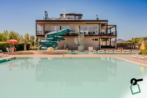 a swimming pool with a water slide in front of a house at Hotiday Lazise Garda in Lazise