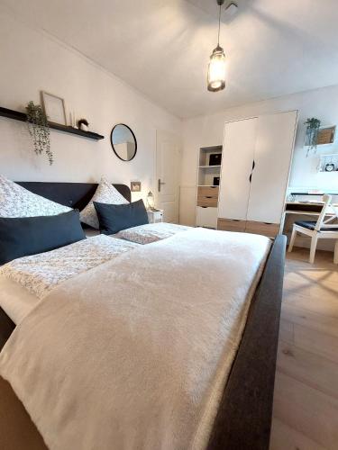 a bedroom with a large white bed with blue pillows at Ferienwohnungen Naheliebe in Bärenbach