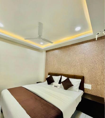 a bedroom with a bed with a ceiling at Hotel MK in Ratlām