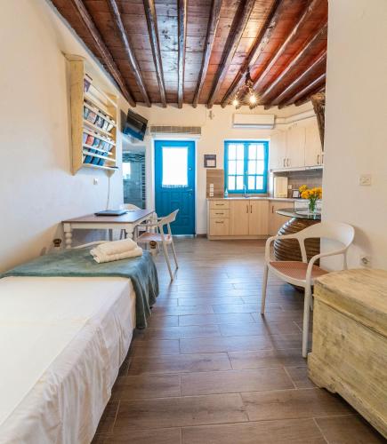 a room with a bed and a table and chairs at Alexandra House in Kimolos