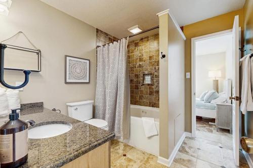 a bathroom with a sink and a toilet and a bed at Sunset Village 31E in Ocean City