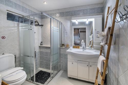 a bathroom with a toilet and a sink and a shower at Villa Angelo Porto Heli - Private Pool in Porto Heli