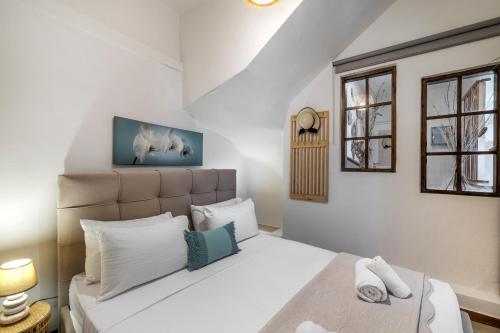 a bedroom with a large white bed with white pillows at Villa Angelo Porto Heli - Private Pool in Porto Heli