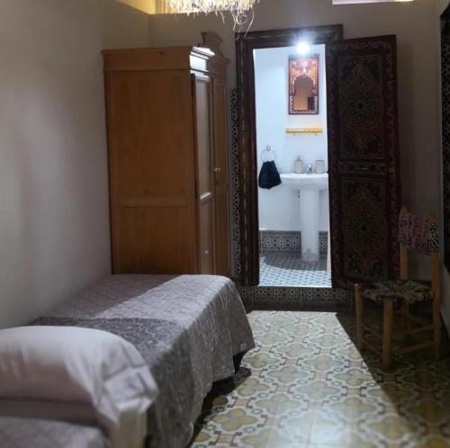 a bedroom with a bed and a mirror and a sink at Riad la madriguera de Tetuan in Tétouan
