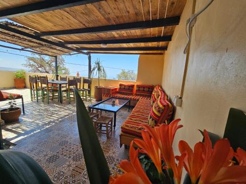 a patio with a couch and a table and chairs at Superbo Stay Sea View Surf House near Taghazout Panoramic Terrace in Taghazout