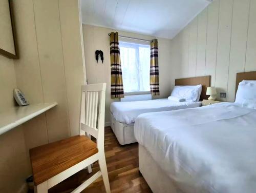 a small room with two beds and a window at Bella Mere Lodge in West Down
