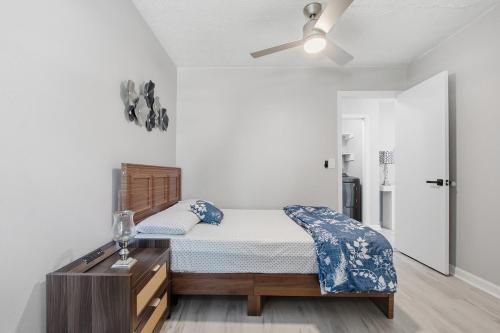 a bedroom with a bed with a dresser and a fan at Elegant Modern Ranch Home in Atlanta
