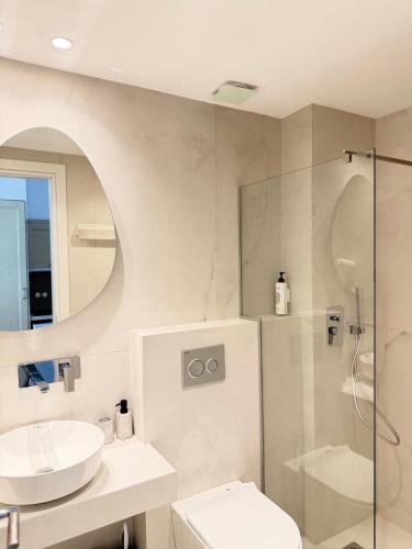 a bathroom with a sink and a toilet and a shower at Myrto Rooms in Pefkochori