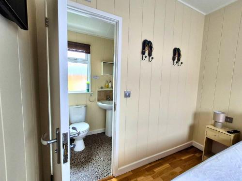 a bathroom with a toilet and a sink at Bella Mere Lodge in West Down