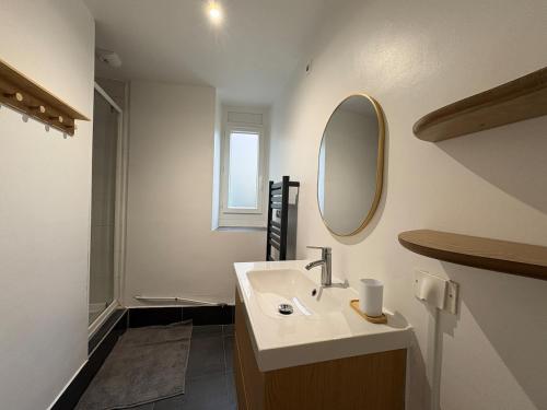 a bathroom with a sink and a mirror at Clécy Chouette maison atypique centre in Clécy