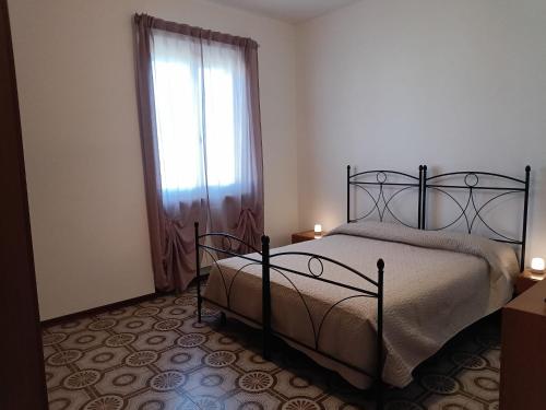 a bedroom with a bed and a window with two candles at Casa Tamerici in Marcelli