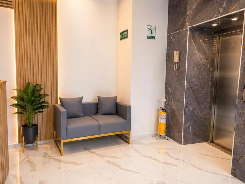 a waiting room with a blue couch in a lobby at Aw Hotel Embassy Corner - Corferias, Embajada EEUU & Vive Claro in Bogotá