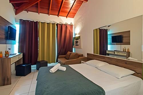 a bedroom with a large bed and a couch at Jungle Beach Maresias in Maresias