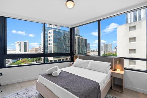 a bedroom with a bed and large windows at Downtown Miami Condo w Pool & Great Location in Miami