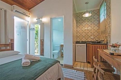 a bedroom with a bed and a kitchen with a sink at Jungle Beach Maresias in Maresias