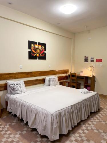a bedroom with a large white bed in a room at Casa Nativa Iquitos in Iquitos