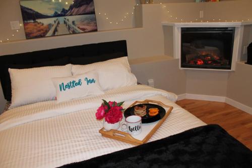 a bed with a tray of food on it at Nestled Inn Bed and Breakfast in Victoria