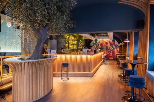 a tree in the middle of a bar with stools at Parkview Boutique Apartments in Vienna