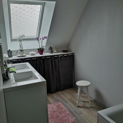 a kitchen with a sink and a window and a stool at Ker valou in Hénansal