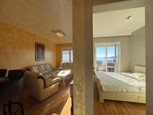 a living room with a couch and a bed and a window at Przno Sea Pearl - Seaview Holiday apartment in Pržno