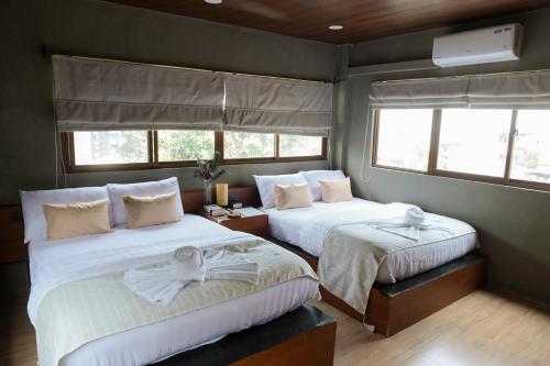 a bedroom with two beds and two windows at Layag La Union in san juan la union