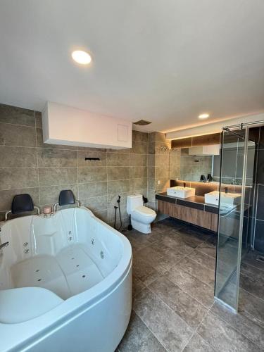 a bathroom with a tub and a toilet and a sink at Walnut Grove Premium Pool Villa in Batu Caves