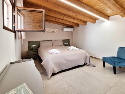 a bedroom with a bed and a blue chair at La Casa Sotto il Campanile in Sciacca