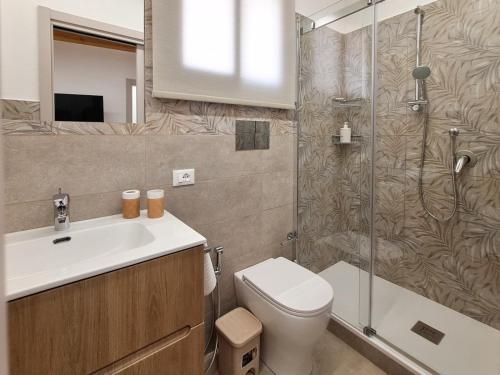 a bathroom with a toilet and a sink and a shower at La Casa Sotto il Campanile in Sciacca