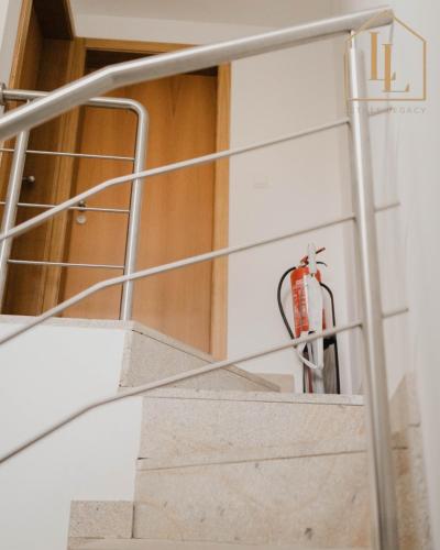 a metal staircase with a fire extinguisher on it at Casa do Foral by Lethes Legacy in Ponte de Lima