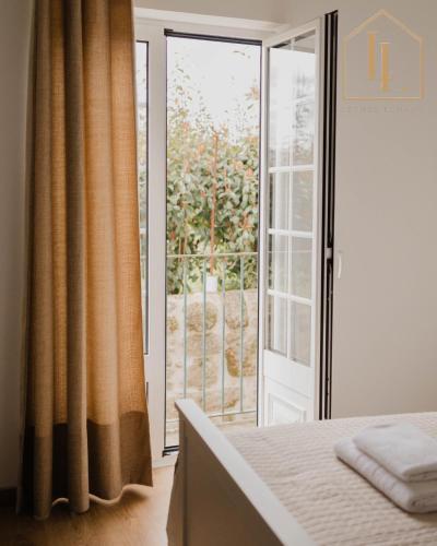 a bedroom with a bed and a sliding glass door at Casa do Foral by Lethes Legacy in Ponte de Lima