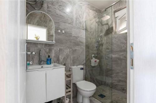a bathroom with a toilet and a glass shower at Apartmani Olga in Stari Bar