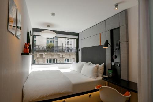 a bedroom with a large bed and a window at citizenM Paris Opera in Paris