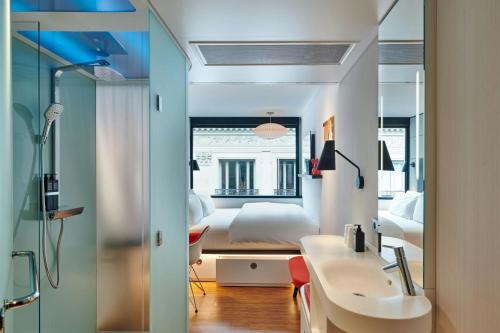 a bedroom with a bed and a sink and a mirror at citizenM Paris Opera in Paris