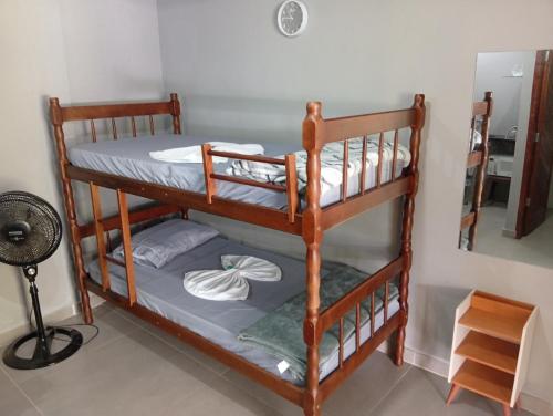 two bunk beds in a room with a fan at Hospedagem estação in Morretes