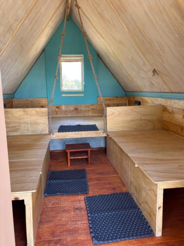 a room in a roof with benches and a table at BellaTiny Campsite with camping cabin for 4 in Windhoek