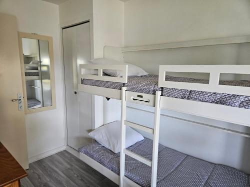 two bunk beds in a small room with a mirror at Plage Pereire Arcachon vue sur mer in Arcachon