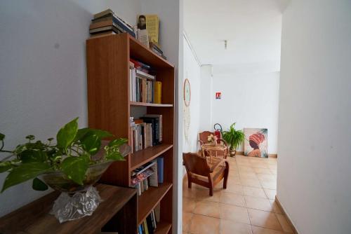 a hallway with a book shelf filled with books at Résidence Le Lagon in Sainte-Anne